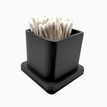 cube-shaped cotton swab holder with an open top that keeps swabs upright, by Dabdock